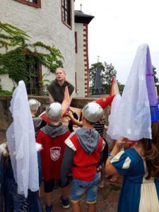 Die Kinder der Kita „Postersteiner Burggeister“ beim Ziehen der drei Gewinner des Kinderburg-Rätsels 2024; Franziska Huberty bei einer Kindertour mit Kindern von der Kita Kastanienhof. (Foto: Burg Posterstein)