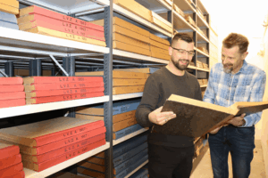 Mike Tänzler (l.) und Daniel Tietz recherchieren in alten Zeitungsbänden. (Foto: Landratsamt)
