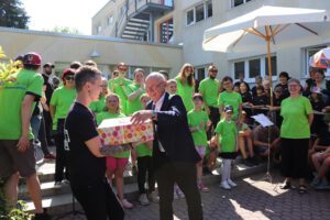Landrat Uwe Melzer übergibt sein Geburtstagsgeschenk, Spielelemente, die das Fühlen und Tasten der Kinder unterstützen, an Schulleiterin Kathleen Schellenberg. (Foto: Landratsamt)